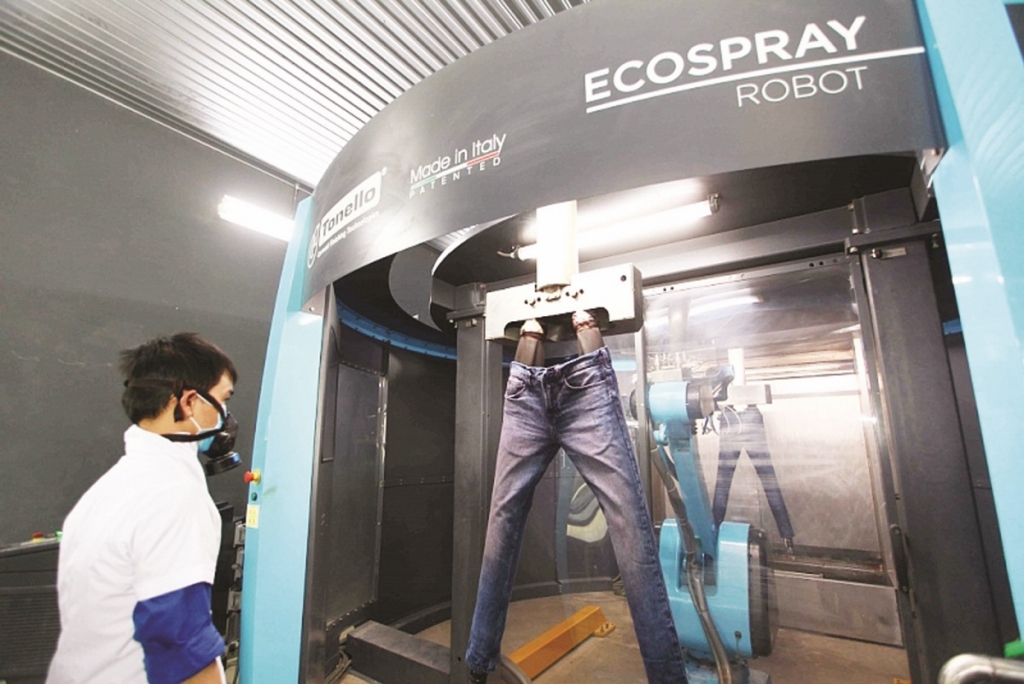 Công nhân vận hành máy laser "mài" quần jean tại Công ty Phong Phú một công nghệ mới hướng tới phát triển bền vững